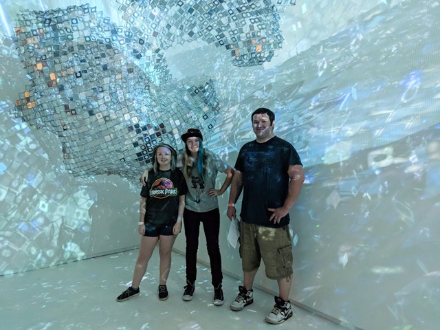 PCC’s Digital Effects and Animation Technology students (l to r) Katie Varner, Christina Cavanaugh, and Christopher Colleen stand inside the installation by Soo Sunny Park called "Photo-Kinetic Grid". 
