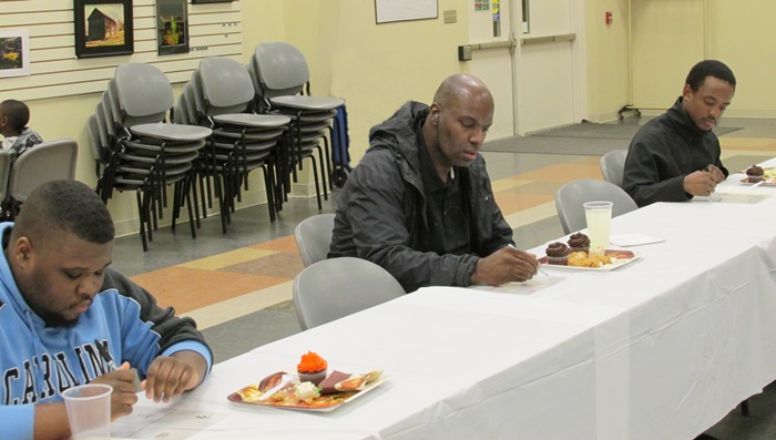 PCC students Tyron Carver, John Laws, and Kent Cash take notes during a Minority Male Mentoring workshop