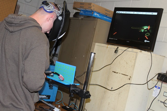 PCC students Chandler Moore (with helmet) learns how to operate PCC’s new welding simulator
