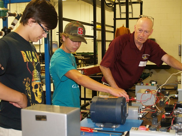 Students work with instructor Dave Wehrenherg on motors