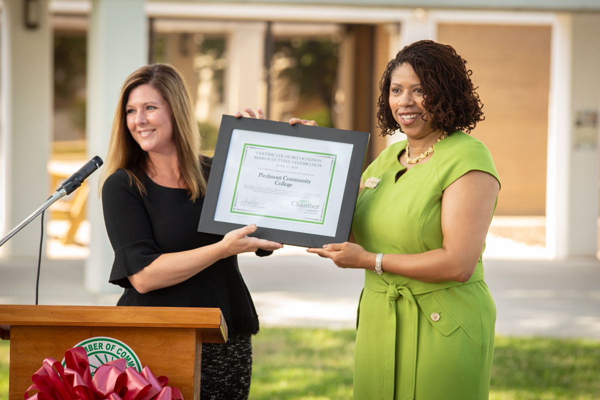 Tracy Harris, Roxboro Area Chamber of Commerce Board Chair presents Dr. Pamela Gibson Senegal, President of Piedmont Community College with a certificate from the Roxboro Chamber.